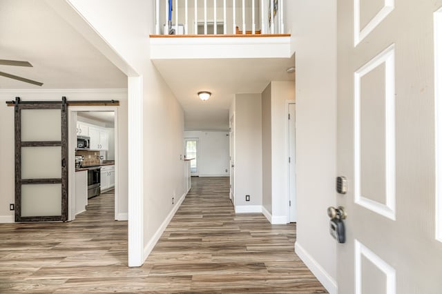 foyer with wood-type flooring and a barn door