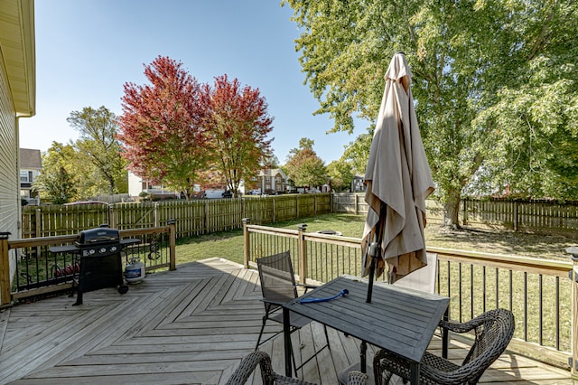 wooden deck with area for grilling and a lawn