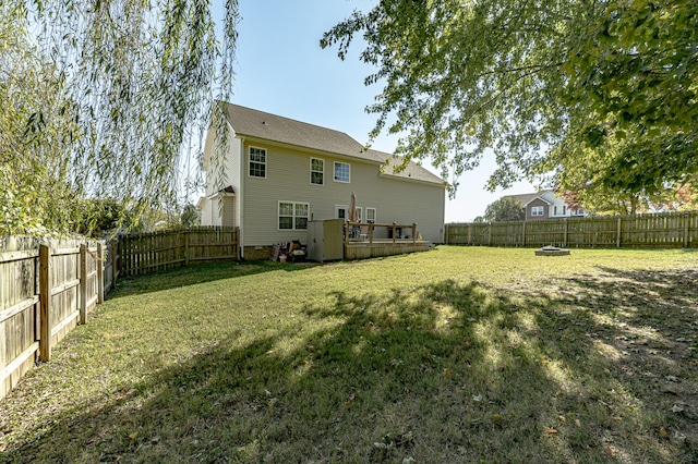 rear view of property featuring a deck and a yard