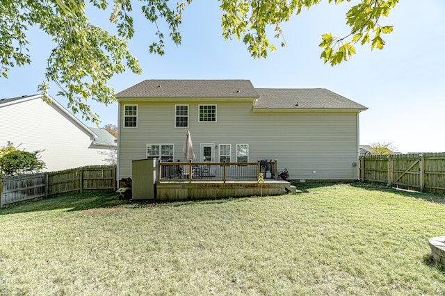 back of property with a yard and a deck