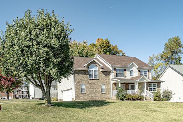 view of front of home featuring a garage, a front lawn, and a porch