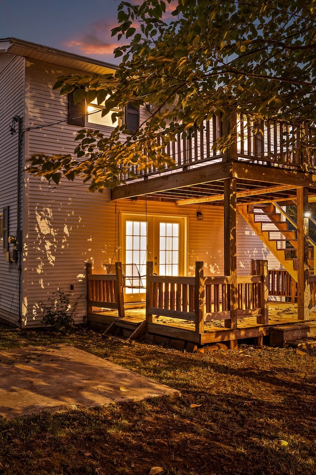 back house at dusk featuring a wooden deck