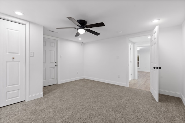 spare room featuring light carpet and ceiling fan