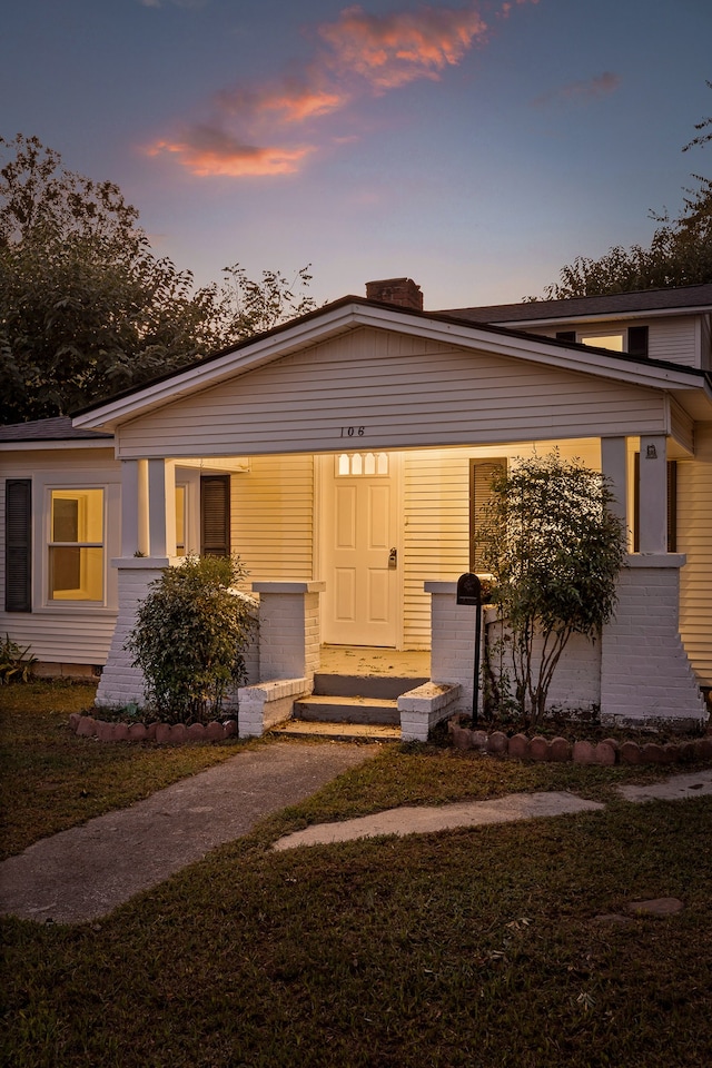 view of front facade featuring a lawn and covered porch