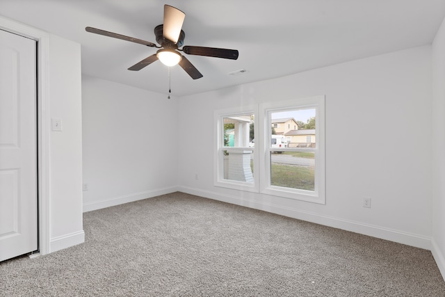 carpeted spare room featuring ceiling fan