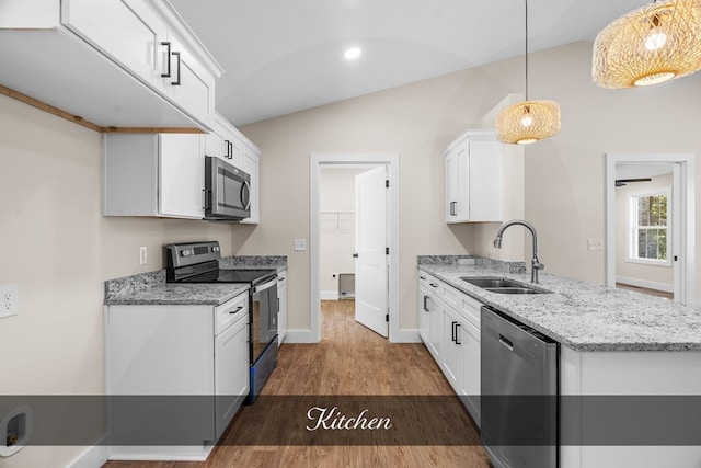 kitchen featuring decorative light fixtures, vaulted ceiling, sink, stainless steel appliances, and white cabinets