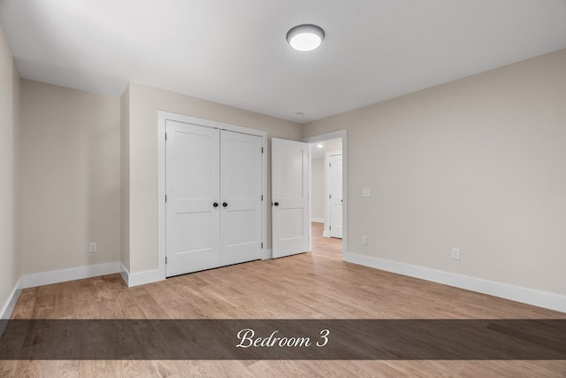 unfurnished bedroom with a closet and light hardwood / wood-style floors