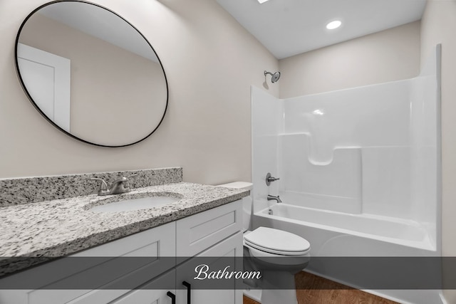 full bathroom with hardwood / wood-style flooring, bathtub / shower combination, vanity, and toilet