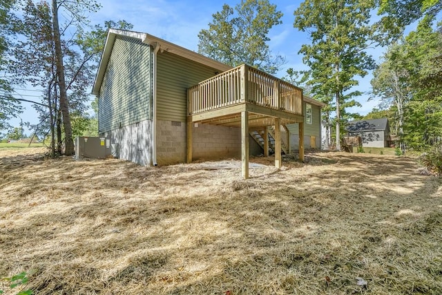 rear view of property featuring a wooden deck