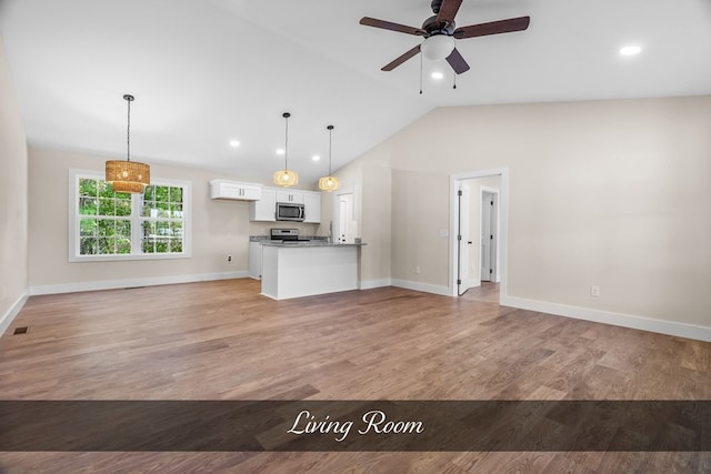 kitchen with pendant lighting, light hardwood / wood-style flooring, white cabinets, and lofted ceiling