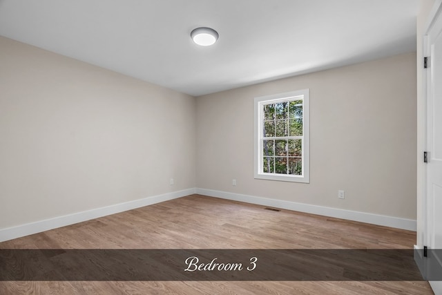 unfurnished room with hardwood / wood-style floors