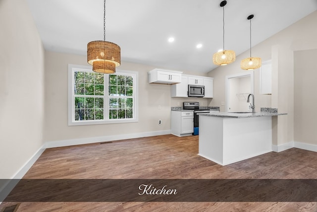 kitchen with light stone countertops, wood-type flooring, white cabinets, kitchen peninsula, and appliances with stainless steel finishes