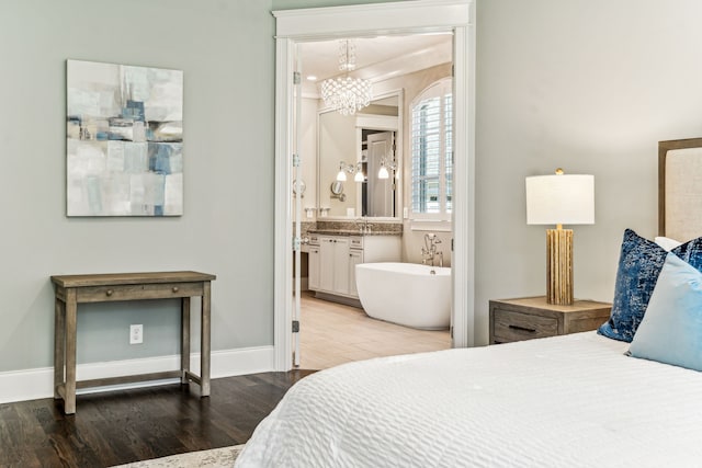 bedroom with crown molding, sink, connected bathroom, and wood-type flooring