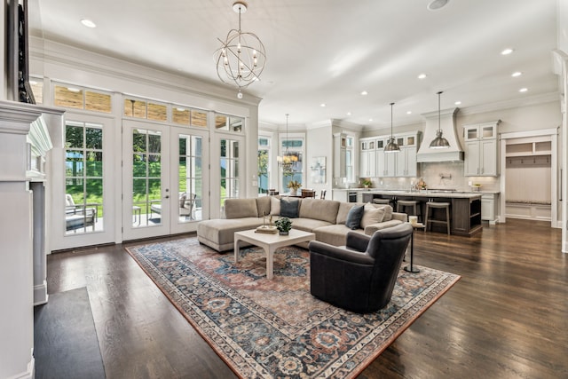 living room with ornamental molding, dark wood-type flooring, french doors, and a chandelier