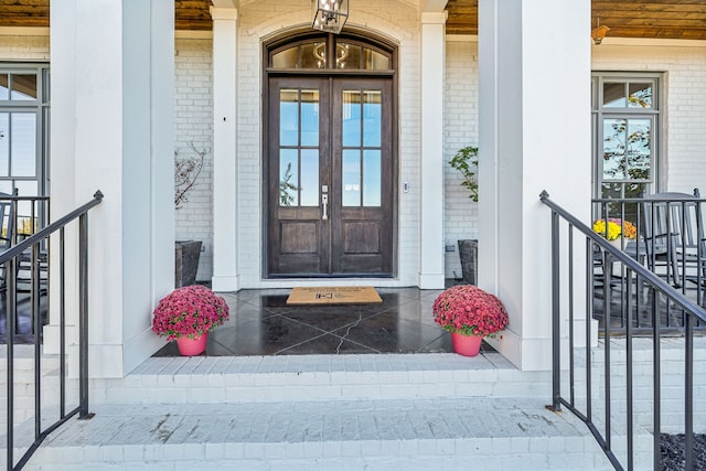 doorway to property with a porch and french doors