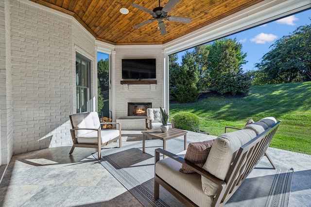 view of patio / terrace with ceiling fan and an outdoor living space with a fireplace