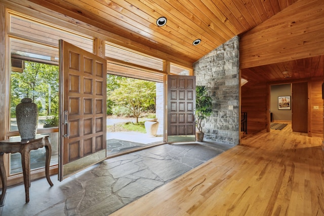 entrance foyer with wooden walls, vaulted ceiling, hardwood / wood-style floors, and wooden ceiling