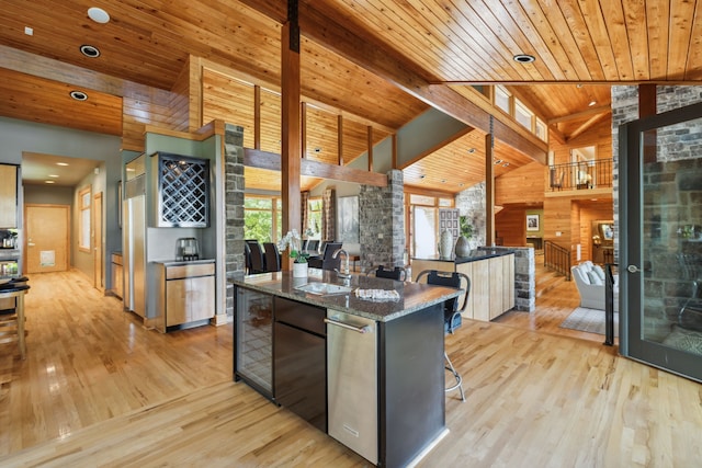 kitchen with sink, a center island, wooden ceiling, beam ceiling, and light hardwood / wood-style floors