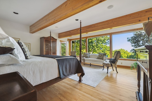 bedroom featuring beamed ceiling and light wood-type flooring