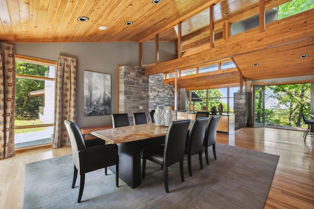 dining area featuring wood ceiling, high vaulted ceiling, and light wood-type flooring