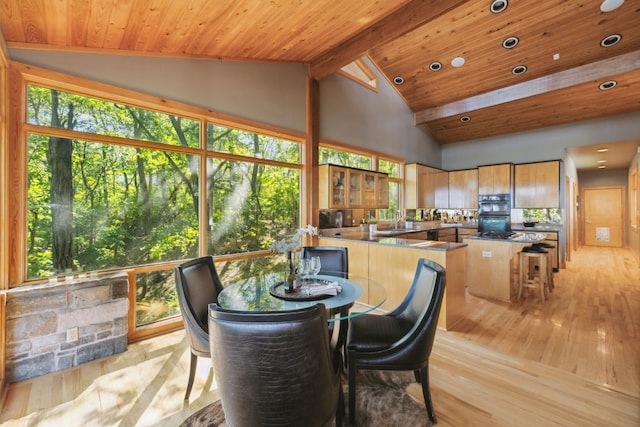 dining space with high vaulted ceiling, beamed ceiling, sink, wooden ceiling, and light hardwood / wood-style flooring