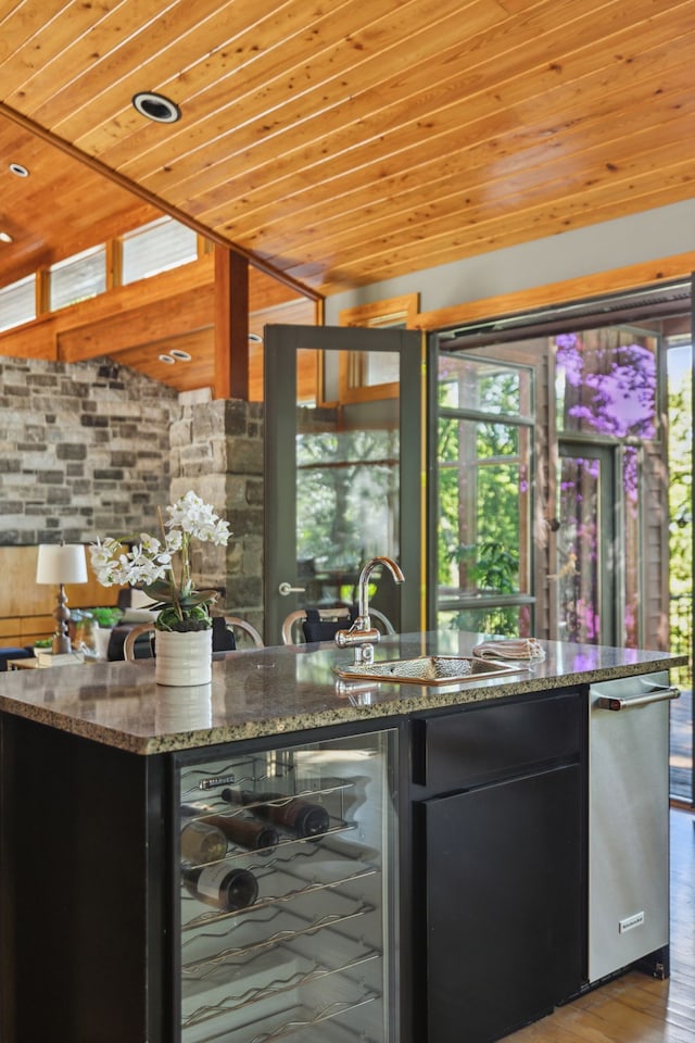 bar featuring stone countertops, wooden ceiling, sink, and beverage cooler