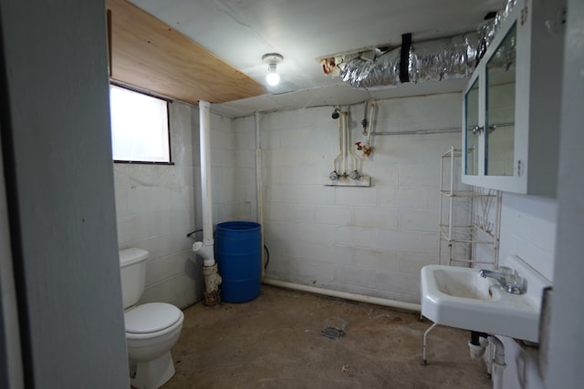 bathroom with sink, concrete floors, and toilet