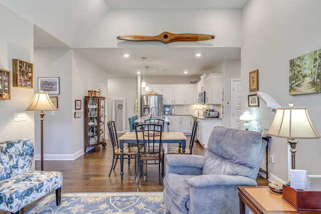 dining area featuring high vaulted ceiling and dark hardwood / wood-style floors