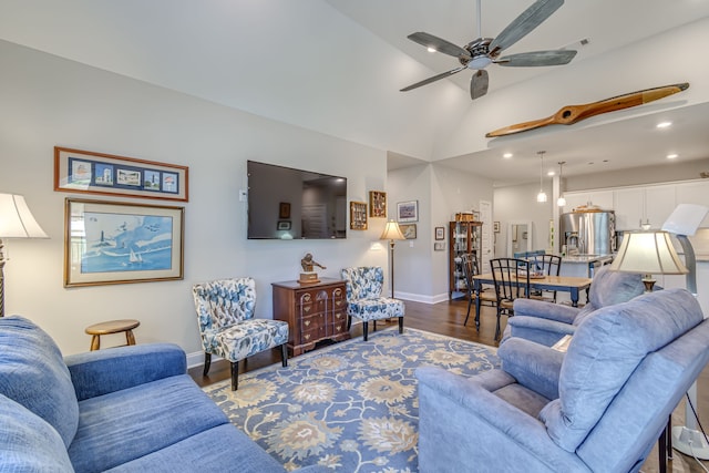 living room with ceiling fan, vaulted ceiling, and hardwood / wood-style floors