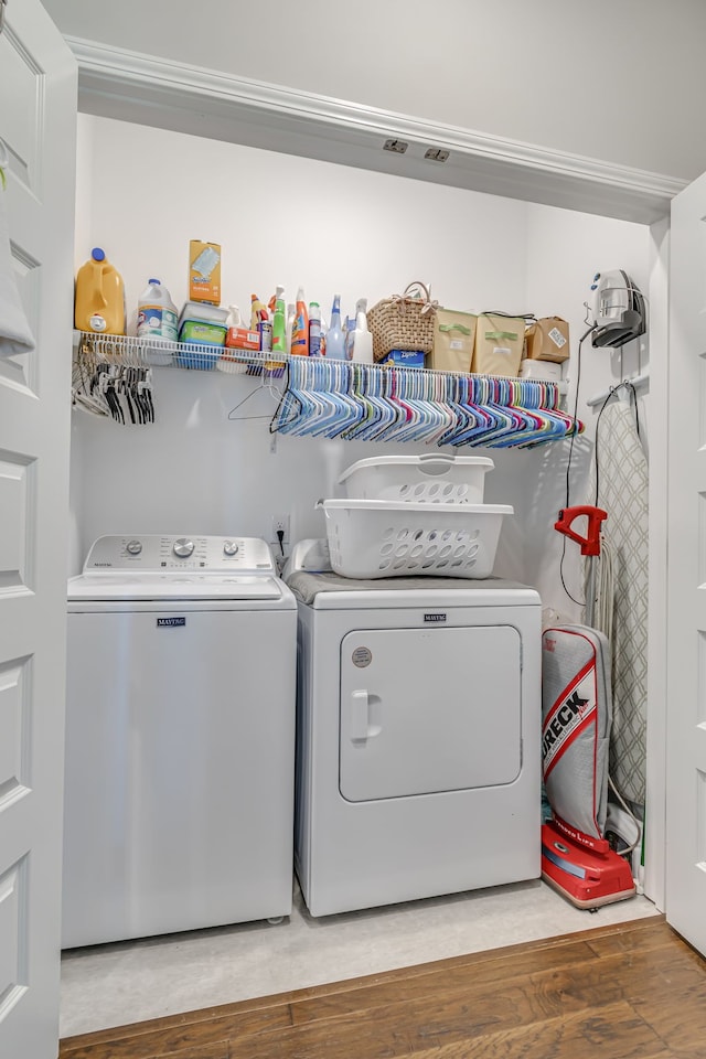 laundry area featuring wood-type flooring and washing machine and dryer