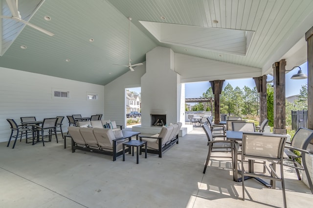 view of patio with an outdoor living space with a fireplace