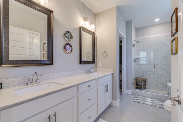 bathroom featuring vanity, tile patterned flooring, a tile shower, and toilet