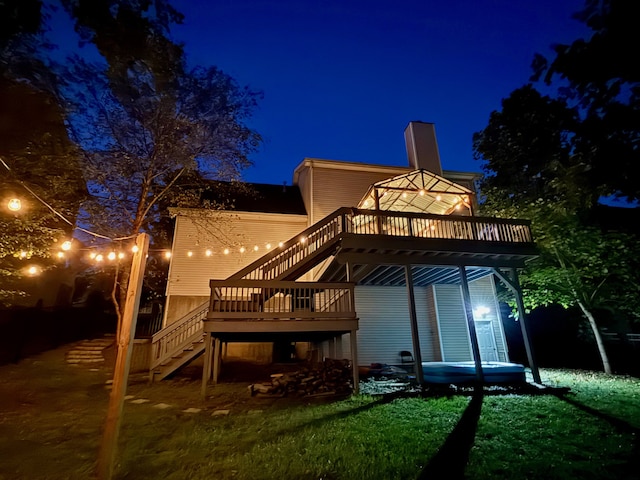 back house at night with a yard and a deck