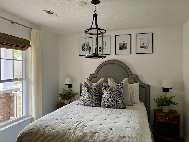 bedroom featuring a textured ceiling and multiple windows