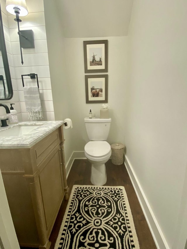 bathroom with toilet, vanity, and hardwood / wood-style floors