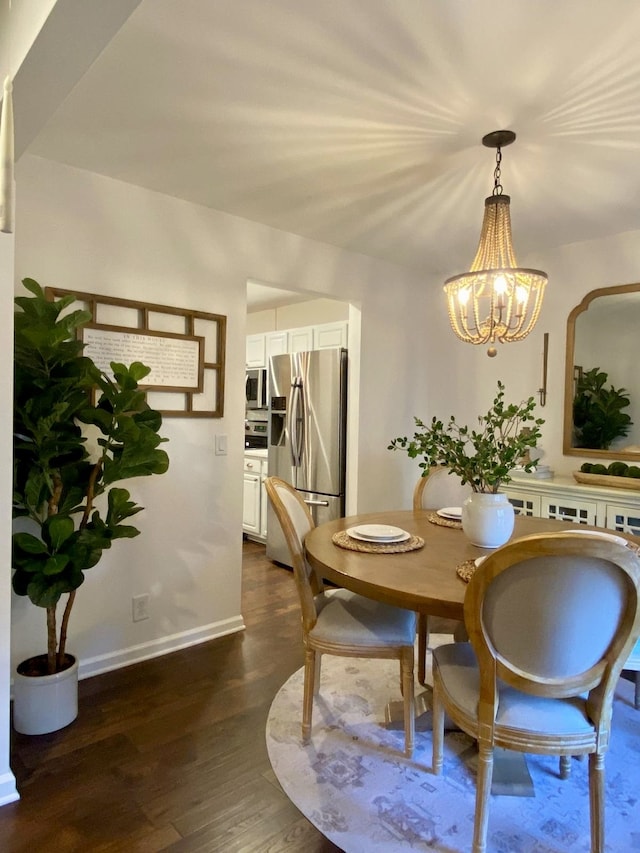 dining space featuring dark hardwood / wood-style flooring and an inviting chandelier