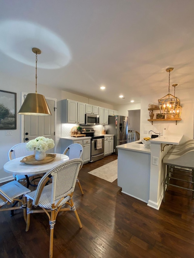 dining room with a notable chandelier, dark hardwood / wood-style floors, and sink