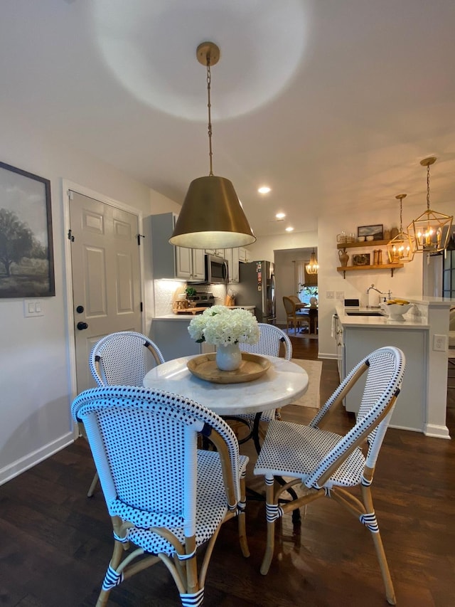 dining space featuring dark wood-type flooring and an inviting chandelier