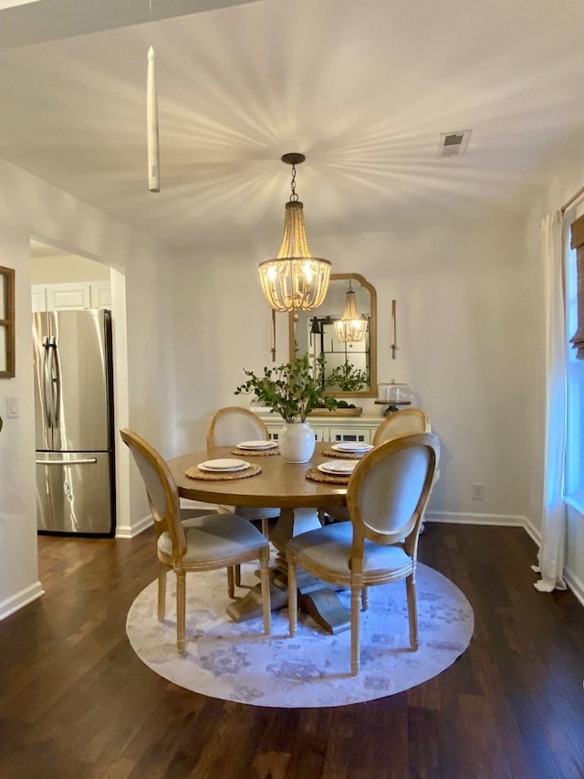 dining room with dark hardwood / wood-style floors and a chandelier