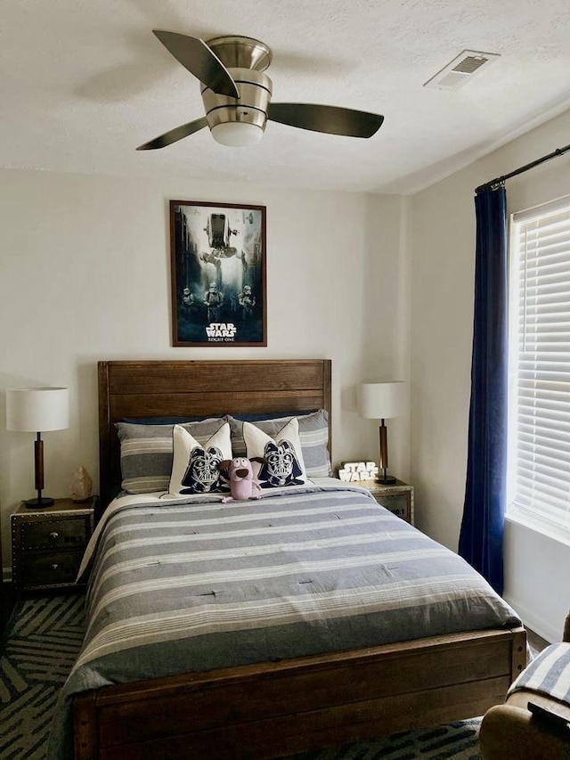 bedroom with ceiling fan and a textured ceiling