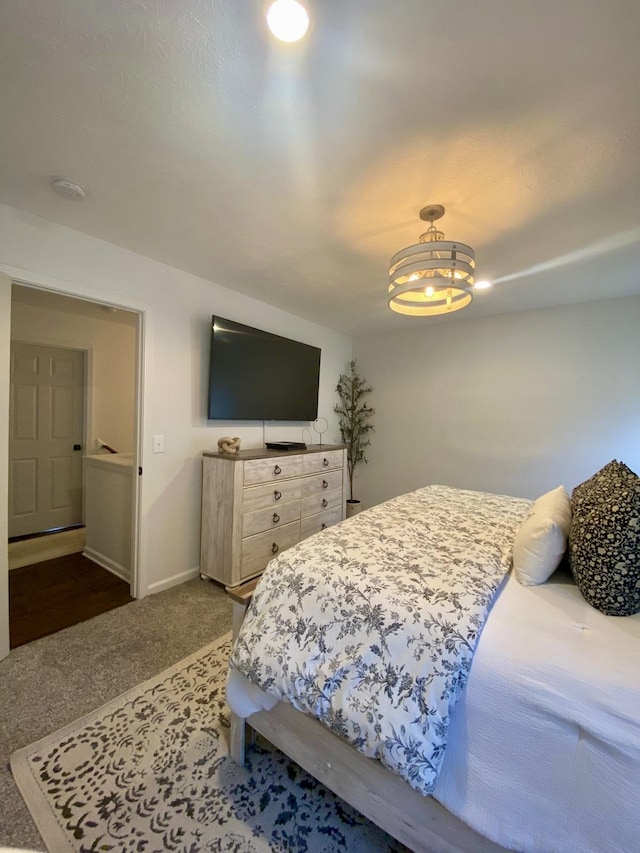 carpeted bedroom with a notable chandelier