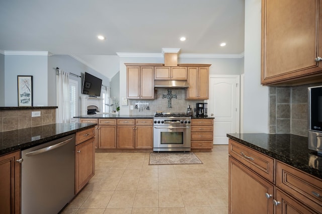 kitchen featuring light tile patterned flooring, crown molding, dark stone countertops, backsplash, and appliances with stainless steel finishes