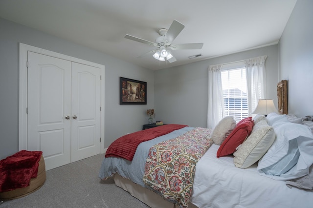 carpeted bedroom with ceiling fan and a closet