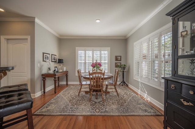 dining space featuring hardwood / wood-style flooring, ornamental molding, and a healthy amount of sunlight