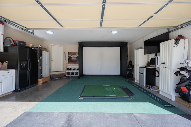 garage featuring black fridge with ice dispenser