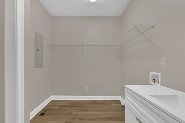 laundry area featuring hookup for a washing machine, electric panel, and dark hardwood / wood-style floors