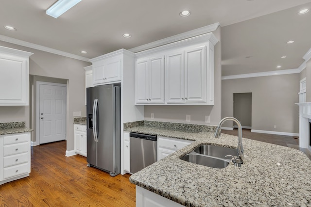 kitchen with appliances with stainless steel finishes, sink, and white cabinets