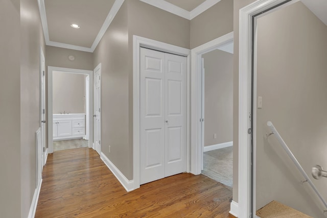 corridor featuring light wood-type flooring and ornamental molding