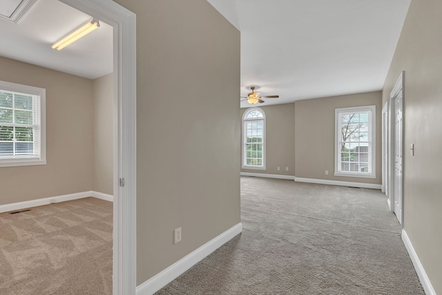 spare room with ceiling fan and light carpet