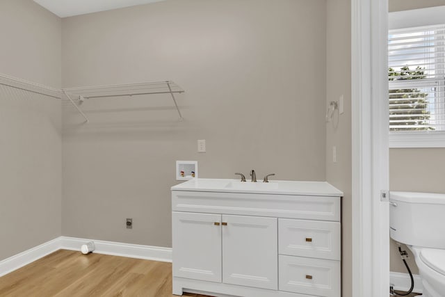 washroom featuring hookup for an electric dryer, hookup for a washing machine, light hardwood / wood-style flooring, and sink